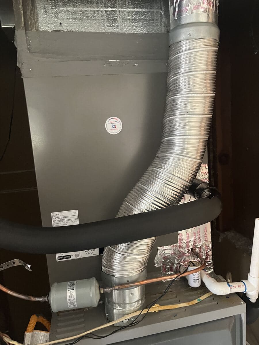 Furnace flue connection and refrigerant line-set detail on a completed Strike Force install